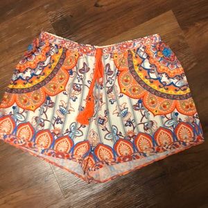 Orange patterned shorts. Tassel tie.